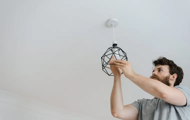 Worker installing a ceiling light fixture