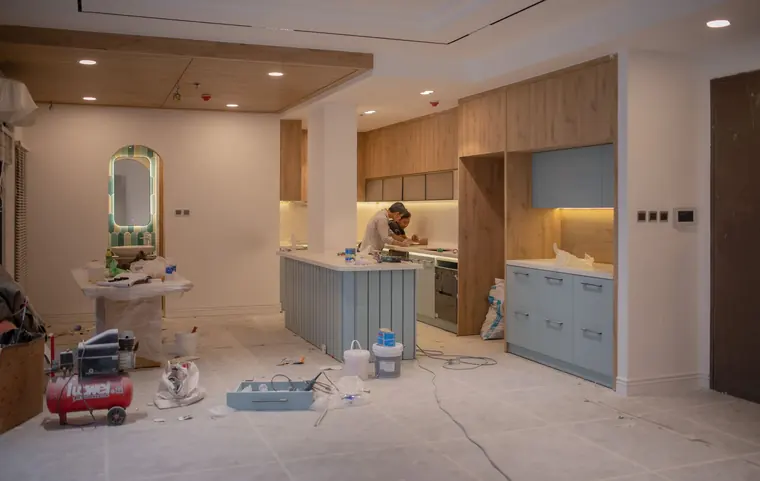Kitchen interior undergoing a small renovation with a worker on site